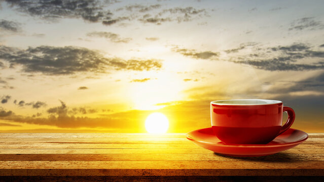 A red coffee cup on a wooden table with a stunning sunrise background, perfect for morning concepts. Good Morning Concept