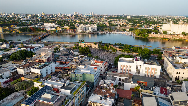 Aerial view of the historic Zona Colonial with its traditional architecture, rooftops, and the Ozama River flowing through the city of Santo Domingo, Distrito Nacional, Dominican Republic.