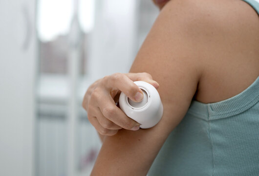 Woman Applying Continuous Glucose Monitor CGM Sensor to Arm