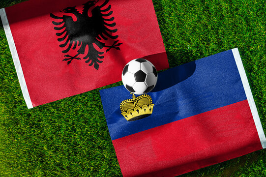 Albania vs. Liechtenstein football match. National flags on green grass with soccer ball in the middle. Football background for international match.