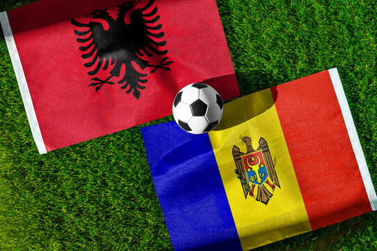 Albania vs. Moldova football match. National flags on green grass with soccer ball in the middle. Football background for international match.