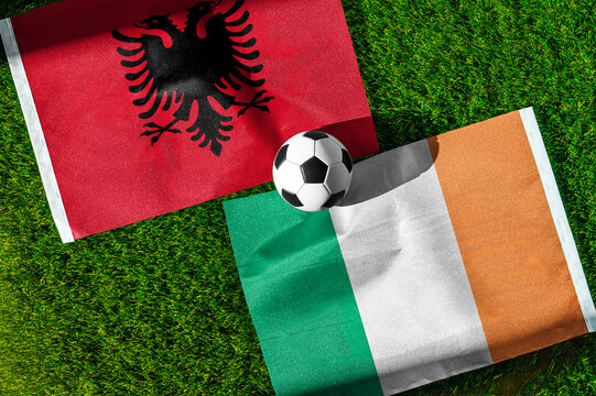 Albania vs. Republic of Ireland football match. National flags on green grass with soccer ball in the middle. Football background for international match.