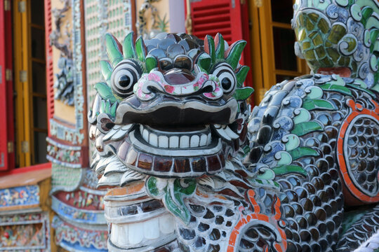 Traditional imperial dragon mosaic porcelain shards sculpture close up, oriental ceramic artwork design on weathered temple facade.