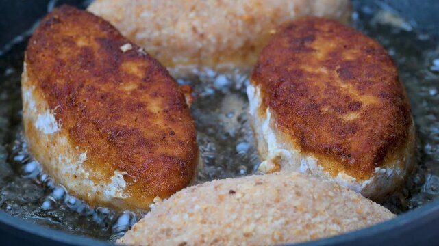 Video of breaded Cordon Bleu schnitzels filled with melted cheese frying