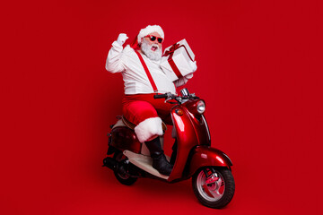 Naklejka premium Santa Claus on a red scooter holding a wrapped gift, celebrating Christmas with festive style and playful holiday spirit