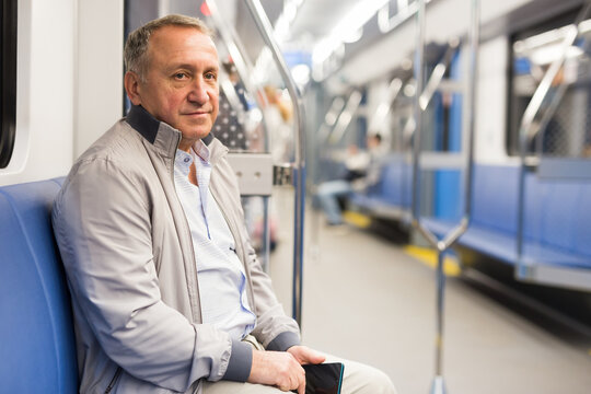 Middle aged man sitting in subway car