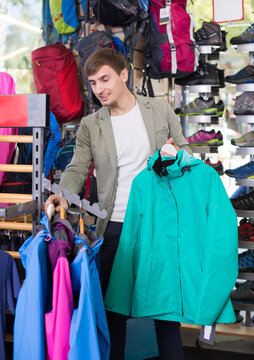 Male shopper chooses sports jacket for outdoor sports