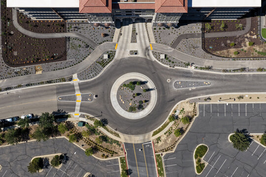 Aerial view of a modern traffic circle surrounded by Silicon Slopes business park office buildings, parking lots, and landscaped grounds in Lehi, Utah, United States.