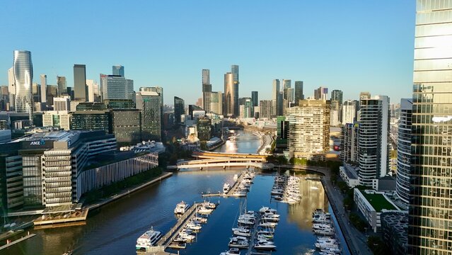 Melbourne CBD, Victoria &ndash; 4K aerial drone view of modern city skyline, Yarra River, Docklands marina, luxury yachts, skyscrapers and waterfront architecture at golden sunset hour