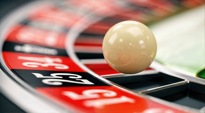 Close-up of a white ivory roulette ball spinning on a red and black wheel. High speed motion blur in a casino. Gambling and luck concept