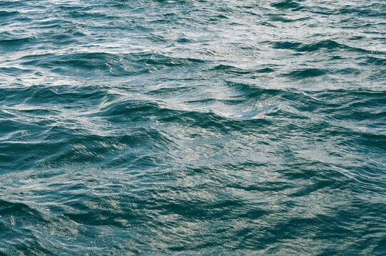 background with blue sea waves on water surface. The texture of the ocean waves