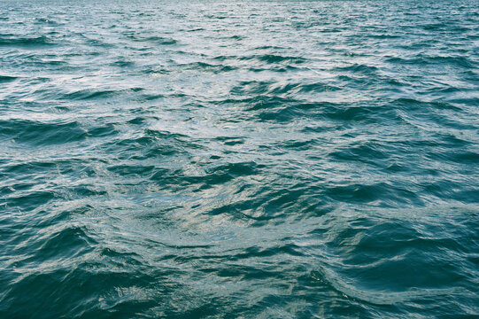 Blue abstract texture with waves on sea. Background with ocean waves and ripples