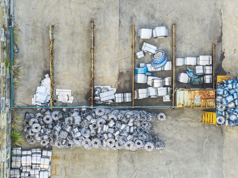 Aerial view of piles of scrap metal coils and industrial waste stored on a concrete yard in Taiwan.