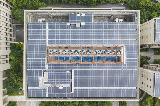 Aerial view of a large building rooftop covered with extensive solar panel arrays and a central HVAC cooling system in Taiwan.