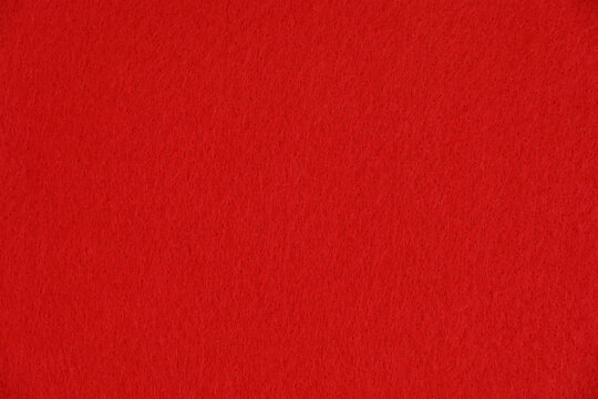 Vibrant scarlet red felt fabric texture background close up view