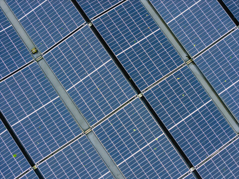 Aerial view of solar panels on a rooftop during a rain shower with water droplets on the surface in Riga, Latvia.