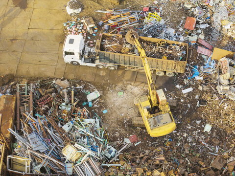 Aerial view of Magnetic excavator moving metal materials at a resource recovery facility