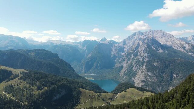 Aerial drone view of K&ouml;nigssee from Jenner mountain in Bavaria, Germany, flying toward the scenic alpine lake surrounded by forests and dramatic peaks of the Berchtesgaden Alps.