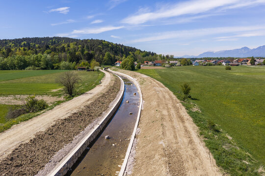 This aerial view shows a river management project with channel widening and embankment construction to enhance flood protection.