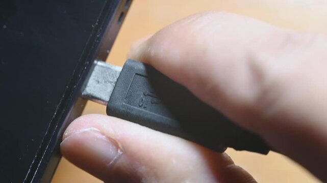 Close-up of USB-C cable plugging and unplugging into smartphone charging port