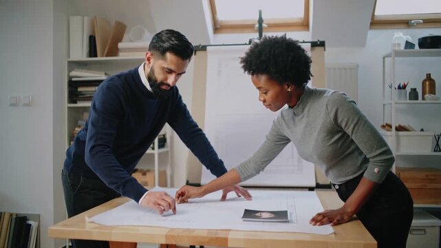 Placing print onto blueprint, man in business wear and woman aligning plans, marking adjustment