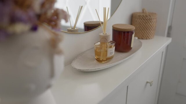 Reed diffuser with wooden sticks and scented oil on a tray, enhancing home decor and providing a pleasant aroma