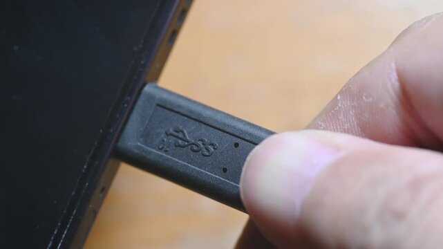 Close-up of USB-C cable plugging and unplugging into smartphone charging port