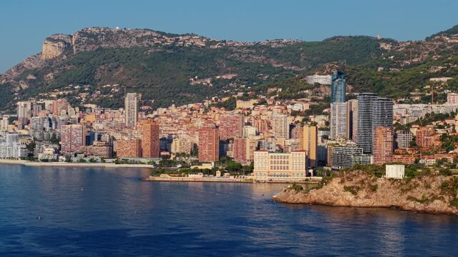 Aerial view of Montecarlo coastline with city buildings and hills in clear daylight
