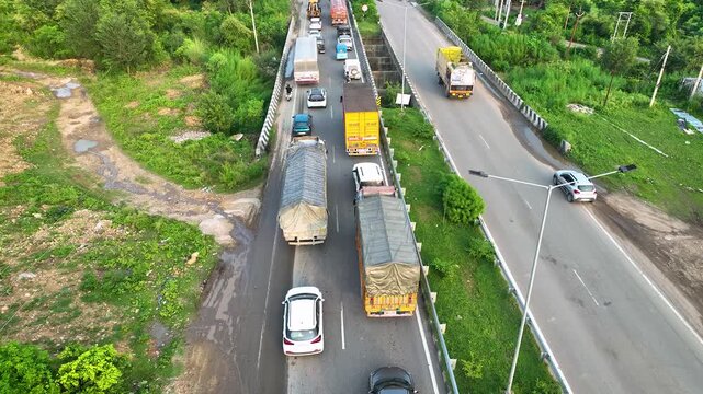 Highway infrastructure expansion bottleneck causing a complete standstill of intercity transport, captured in a tight aerial tracking sequence.