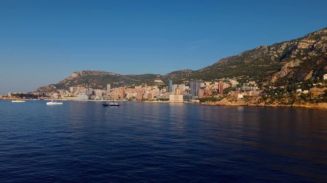 Aerial view of Montecarlo coastline with city buildings and mountains at sunset