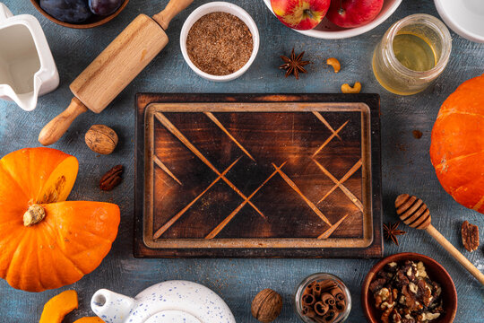 Fall baking, cooking seasonal dessert background with various ingredients - honey, pumpkin squash, brown sugar, cinnamon, spices, red apples, plums, walnuts, pecans. Autumn, thanksgiving bakery backgr