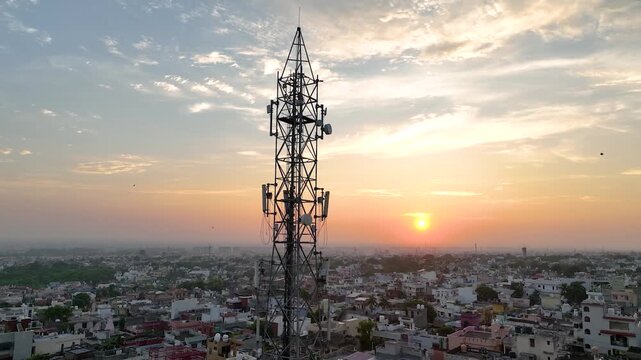 Tight drone orbit around mobile cell telecom tower antennas over an overpopulated unplanned Indian city.