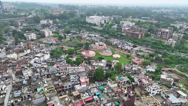 Drone overview of chaotic urban housing transitioning to a municipal sewage treatment plant highlighting city planning.