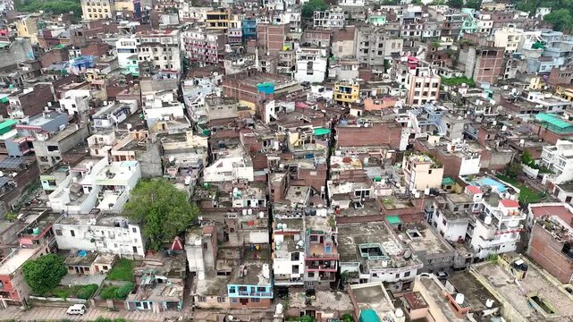 4K aerial nadir glide above chaotic concrete rooftops highlighting poor urban planning and overpopulation.