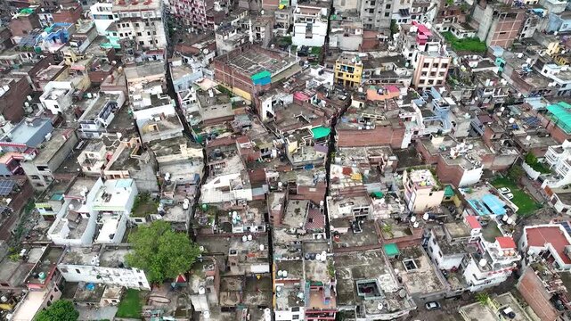 Aerial pullback revealing a dense unplanned Indian city built on the banks of a flood-prone muddy river.
