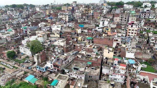 Aerial orbit over an overpopulated Indian city highlighting chaotic architecture and poor urban planning.