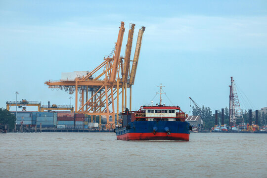 Calm marine logistics network with cargo ship sailing near industrial harbor port crane for global trade transport delivery