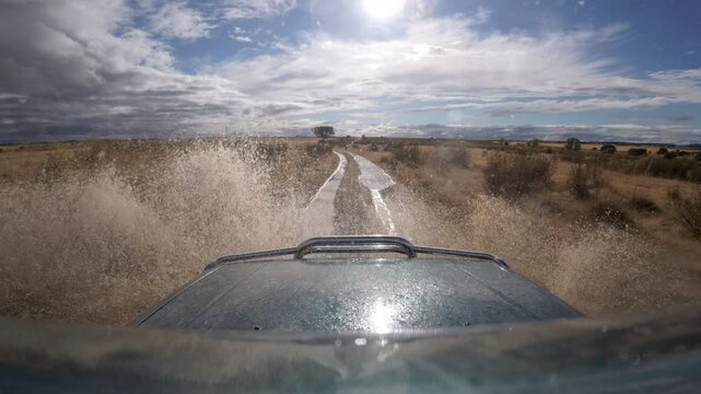 Slow Motion Off Road Splash Across Muddy Ruts on Arid Plain