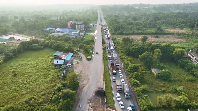 Drone view showing commercial trucks, busses and passenger cars stuck at a highway infrastructure project.