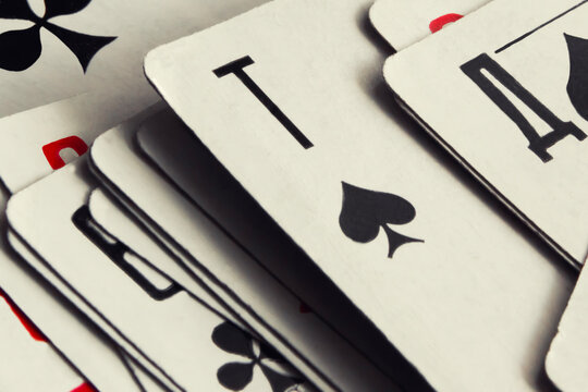 Close-Up of Stacked Playing Cards Showing Spade Ace and Game Symbols for Casino and Poker