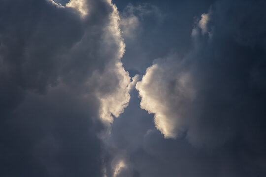 Dramatic Storm Clouds Opening Over Dark Evening Sky With Backlit Silver Linings and Contrast