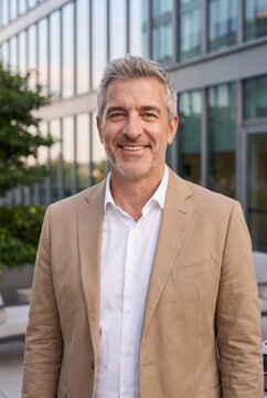 Senior businessman smiling confidently outside an office building