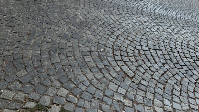 Vintage cobblestone pavement texture with wavy pattern on city street