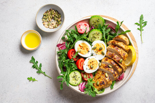 High protein lunch bowl with chicken, eggs and vegetable salad.