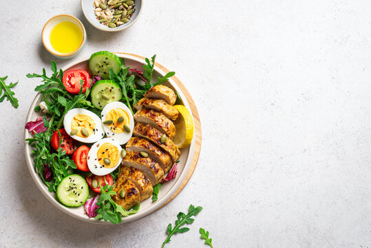 High protein lunch bowl with chicken, eggs and vegetable salad.
