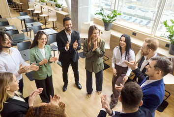 Business team meeting people applause success celebration. Coworkers stand in a circle, clapping...