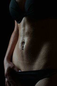 Low-Key-Aufnahme einer Frau in schwarzer Lingerie mit dramatischem Seitenlicht und feinem Spr&uuml;hnebel. Sinnliche Boudoir-Fotografie, K&ouml;rper&auml;sthetik, Beauty, Glamour und Fine Art.