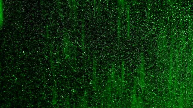 A close up of snow and frosty patterns in green light on a window, creating a mesmerizing winter texture.