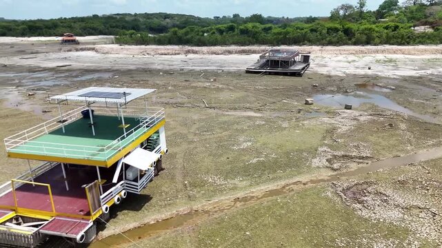 Floating houses stranded on dry land after a lake dried up due to extreme drought linked to climate change.