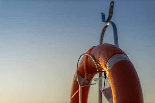 Orange Marine Life Ring on Sailing Boat at Sunrise with Sky Copy Space